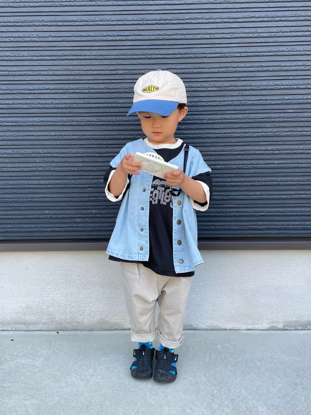 ブラック系のTシャツ/カットソー、ブルー系のベスト、ホワイト系のパンツを着用したキッズの春コーディネートの2枚目の写真