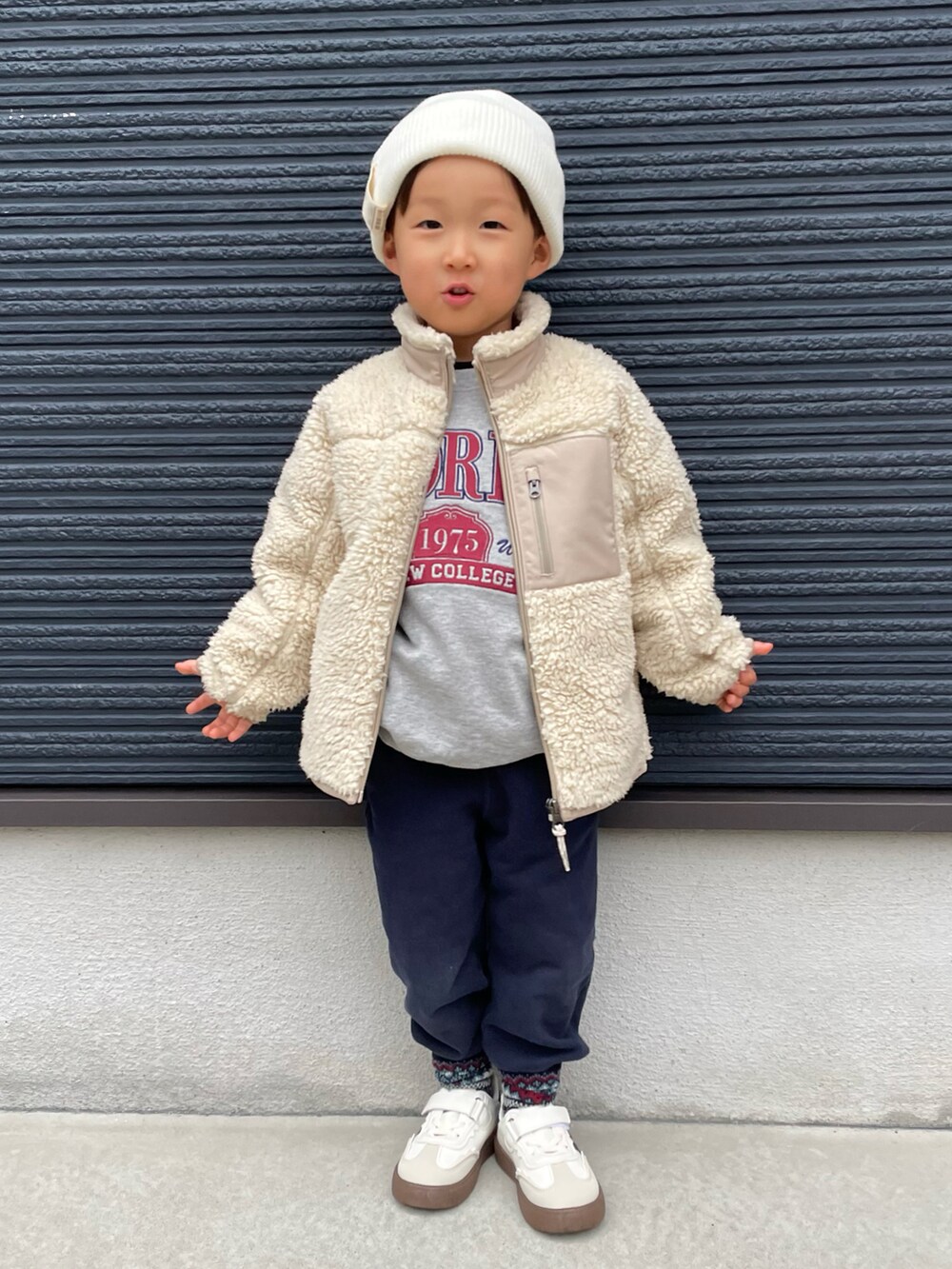 グレー系のスウェット、ベージュ系のその他アウター、ブルー系のスウェットパンツを着用したキッズの冬コーディネートの3枚目の写真