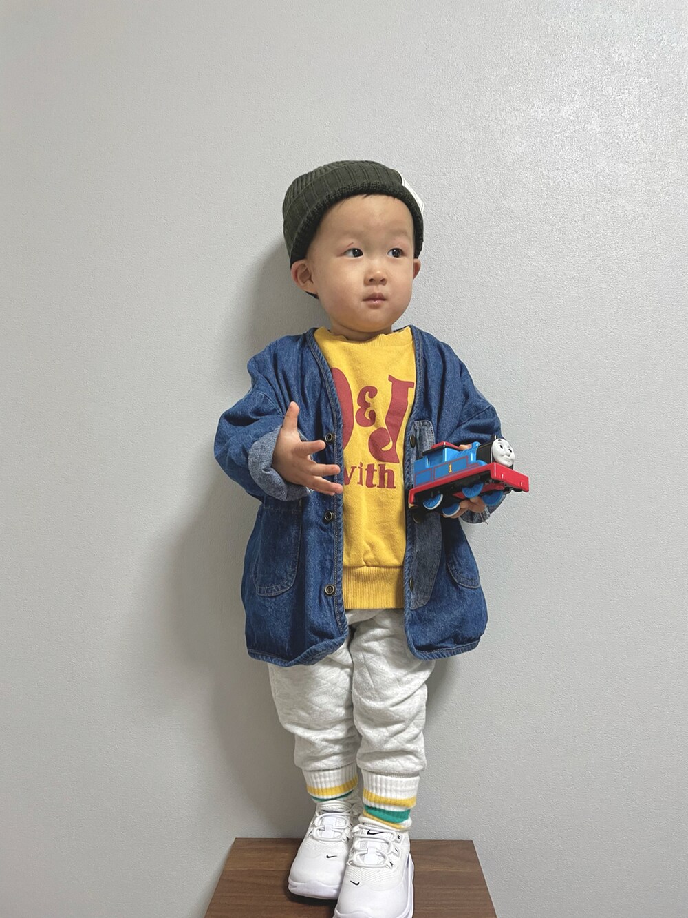 イエロー系のスウェット、ブルー系のデニムジャケット、ホワイト系のその他パンツを着用したキッズの冬コーディネートの2枚目の写真