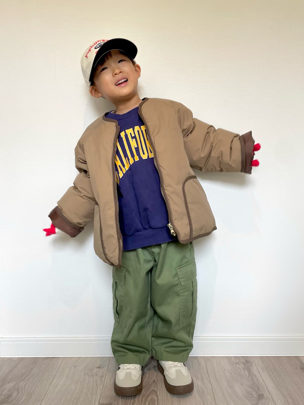 ブルー系のスウェット、ブラウン系のノーカラージャケット、グリーン系のカーゴパンツを着用したキッズの冬コーディネートの4枚目の写真