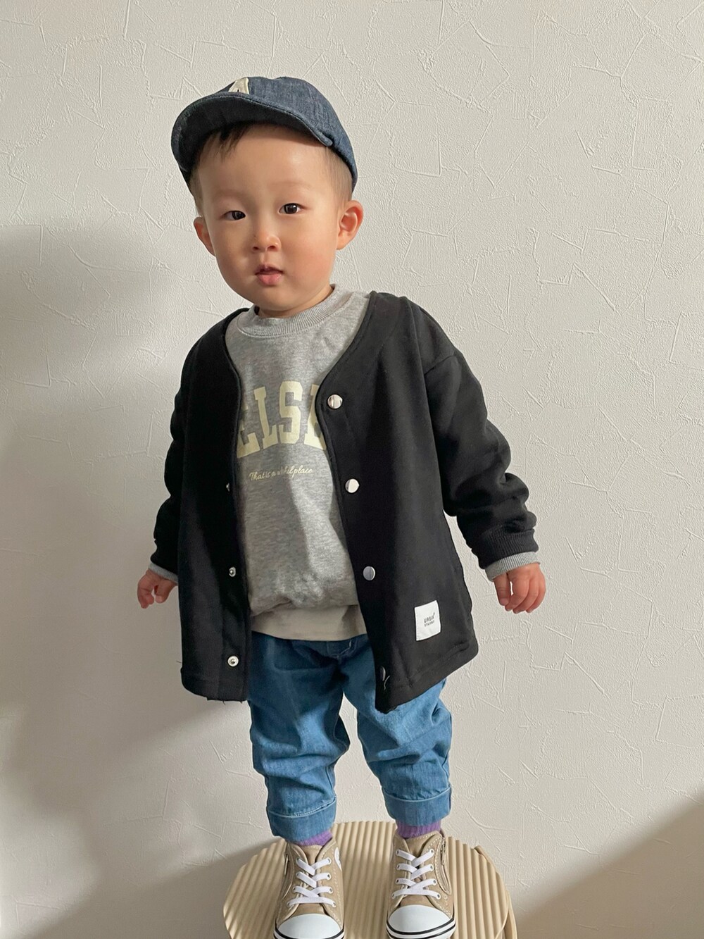 グレー系のスウェット、ブルー系のデニムパンツ、ベージュ系のスニーカーを着用したキッズの春コーディネートの3枚目の写真