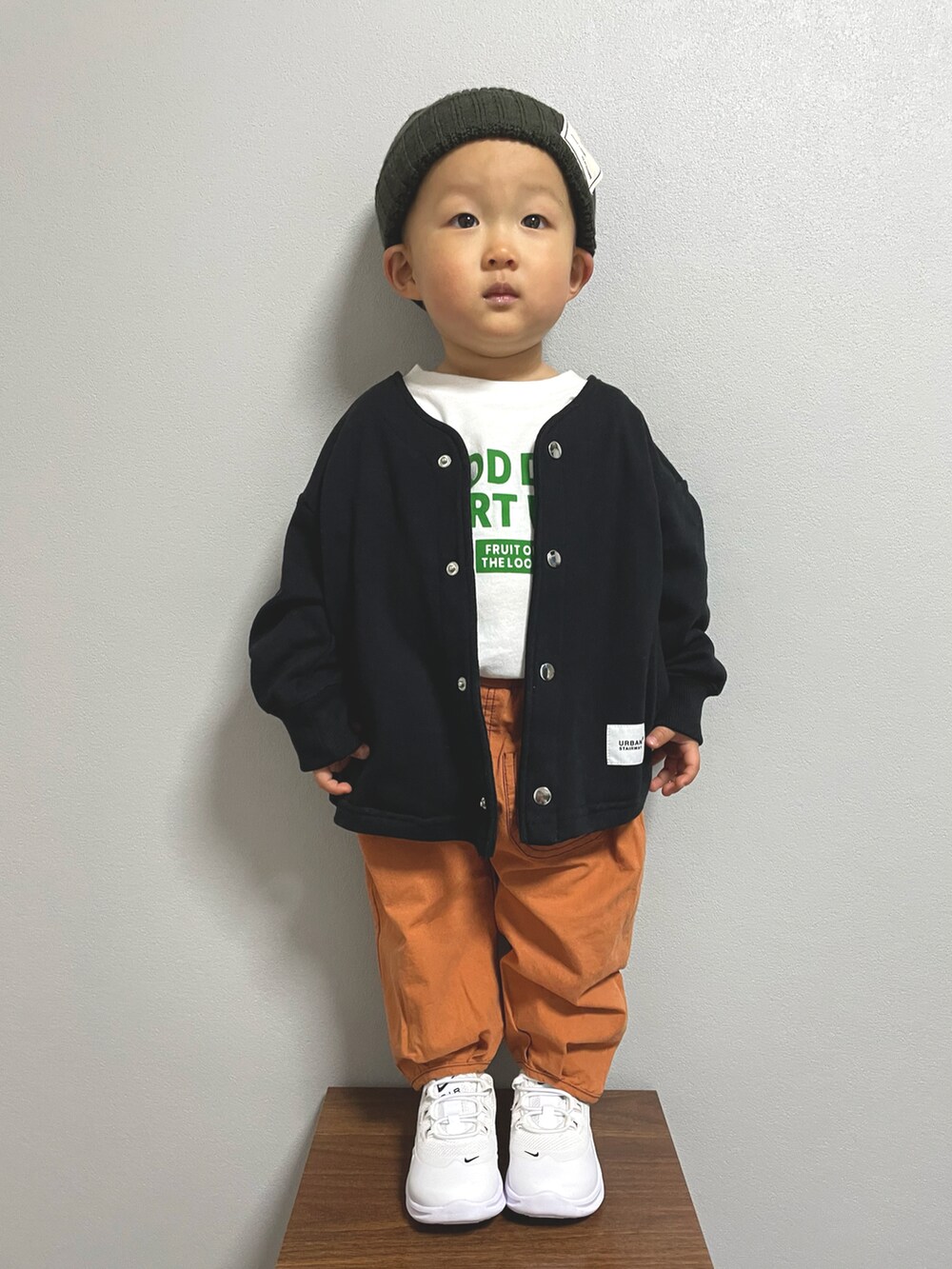 ホワイト系のTシャツ/カットソー、ブラック系のノーカラージャケット、ホワイト系のスニーカーを着用したキッズの冬コーディネートの2枚目の写真