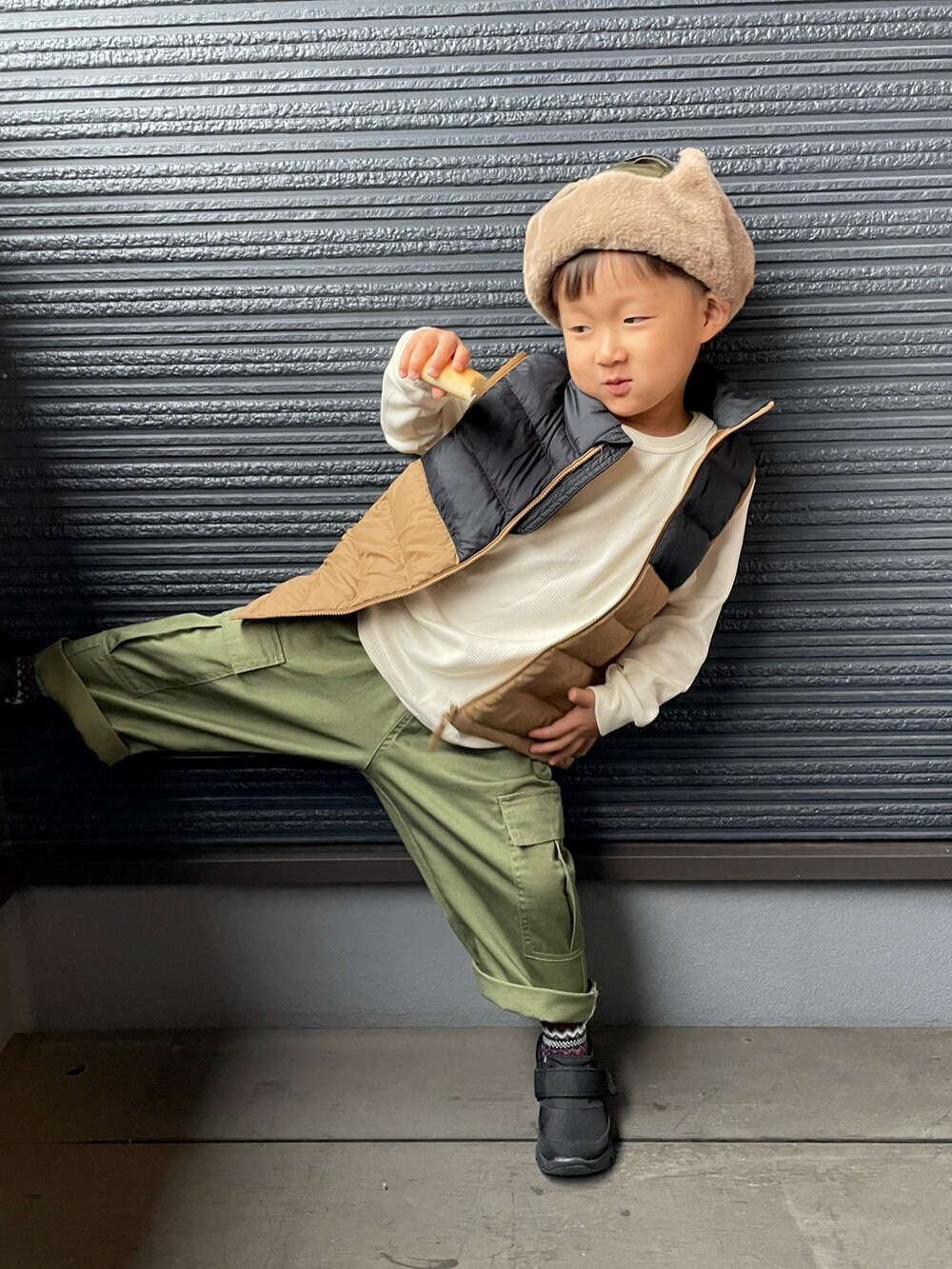 ブラウン系のダウンジャケット/コート、ブラック系のスニーカー、ブルー系のソックス/靴下を着用したキッズの秋コーディネートの4枚目の写真