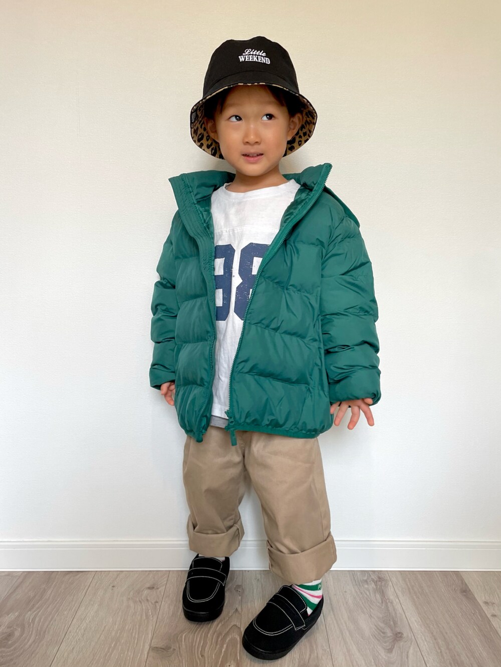 ホワイト系のTシャツ/カットソー、グリーン系のダウンジャケット/コート、ベージュ系のチノパンツを着用したキッズの冬コーディネートの3枚目の写真