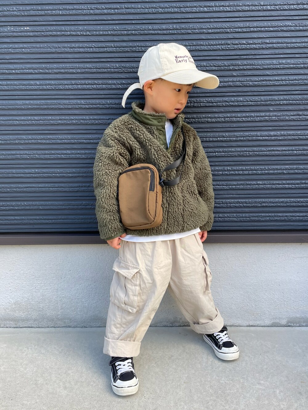 グリーン系のブルゾン、ブラウン系のショルダーバッグ、ベージュ系のその他パンツを着用したキッズの秋コーディネートの3枚目の写真
