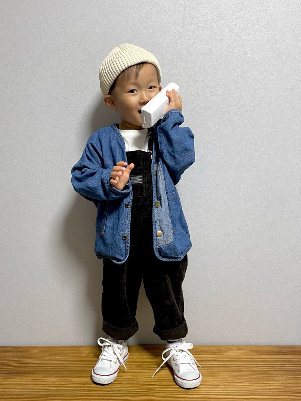ブルー系のデニムジャケット、グレー系のサロペット/オーバーオール、ホワイト系のスニーカーを着用したキッズの秋コーディネートの3枚目の写真