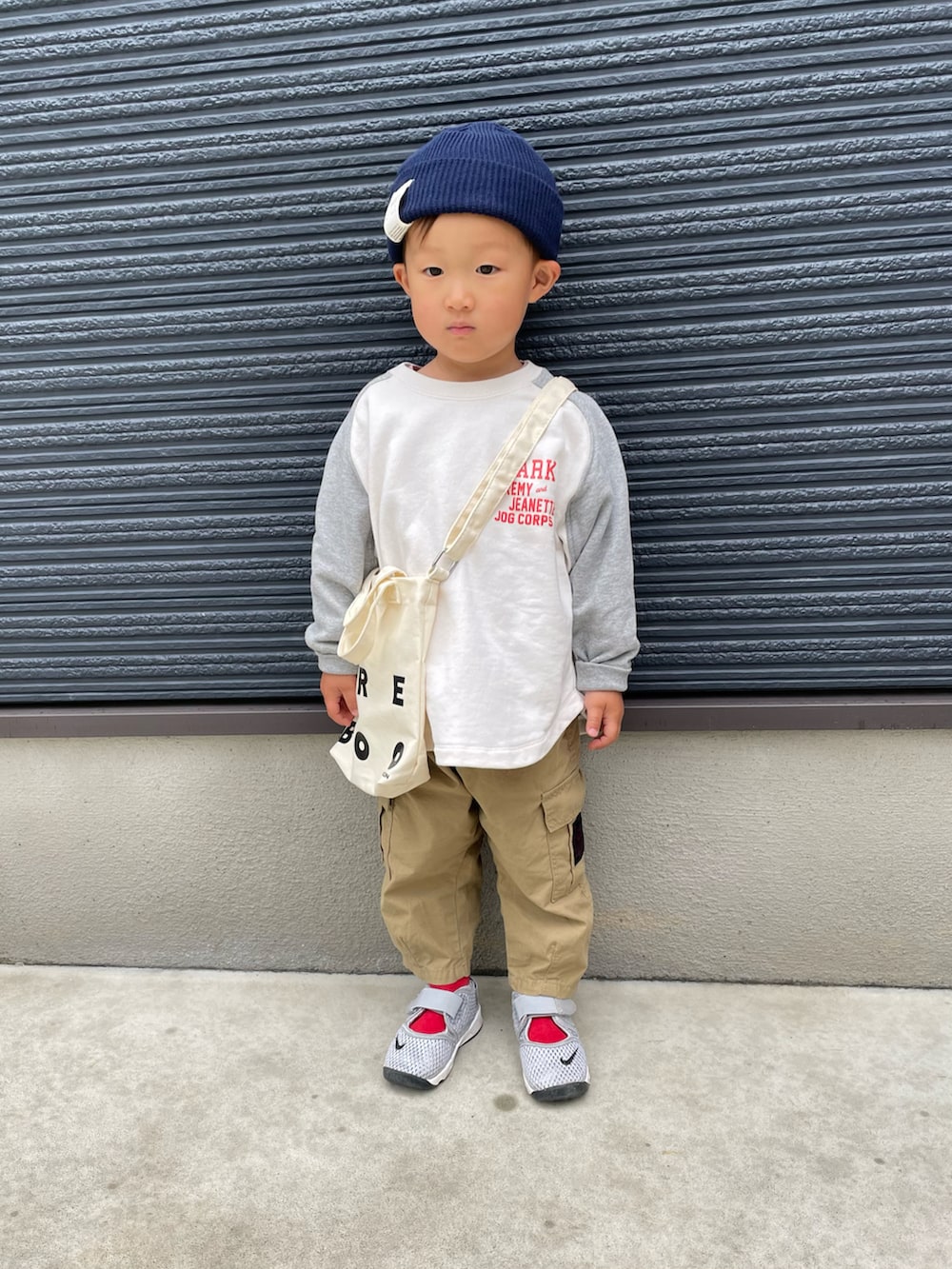 グレー系のスウェット、ベージュ系のカーゴパンツ、グレー系のスニーカーを着用したキッズの春コーディネートの2枚目の写真