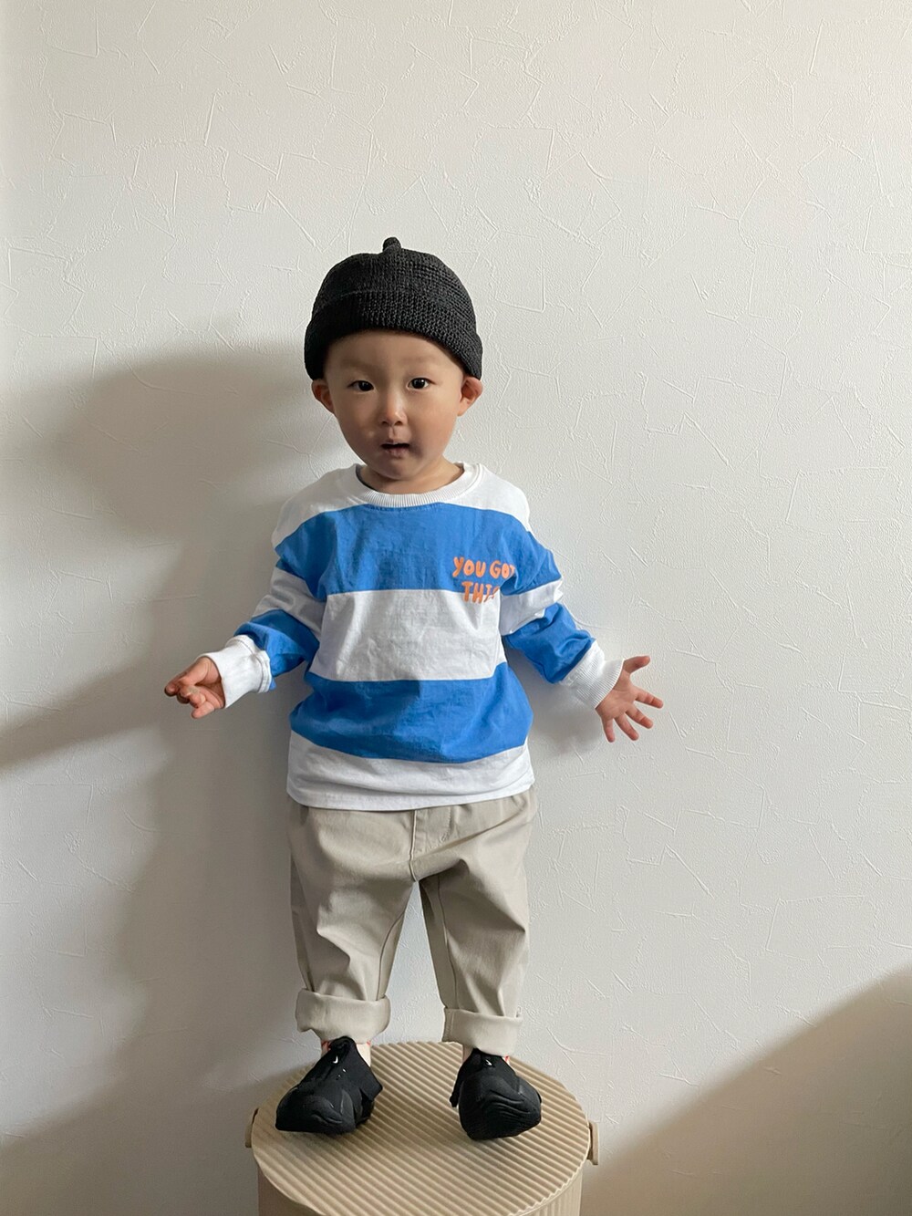 ホワイト系のTシャツ/カットソー、ブラック系のサンダル、ブラック系のキャップを着用したキッズの春コーディネートの2枚目の写真