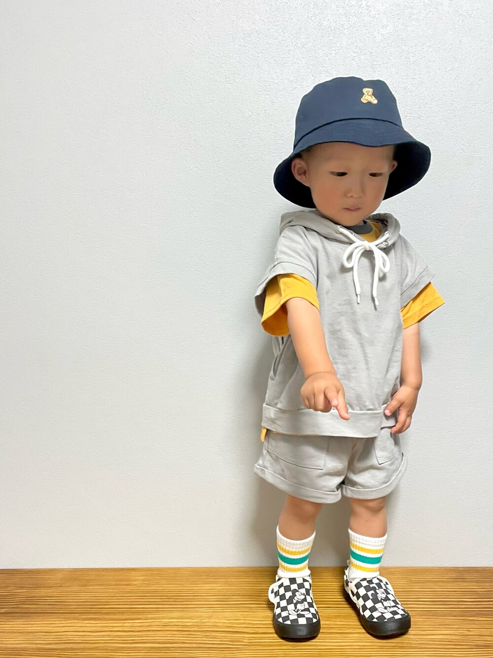 グレー系のスウェット、ブラック系のスリッポン、オレンジ系のTシャツ/カットソーを着用したキッズの春コーディネートの2枚目の写真