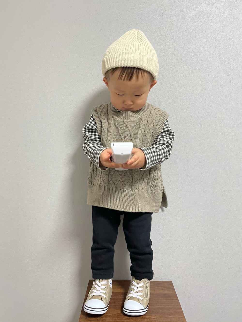 ブラック系のTシャツ/カットソー、グリーン系のベスト、ベージュ系のスニーカーを着用したキッズの冬コーディネートの3枚目の写真