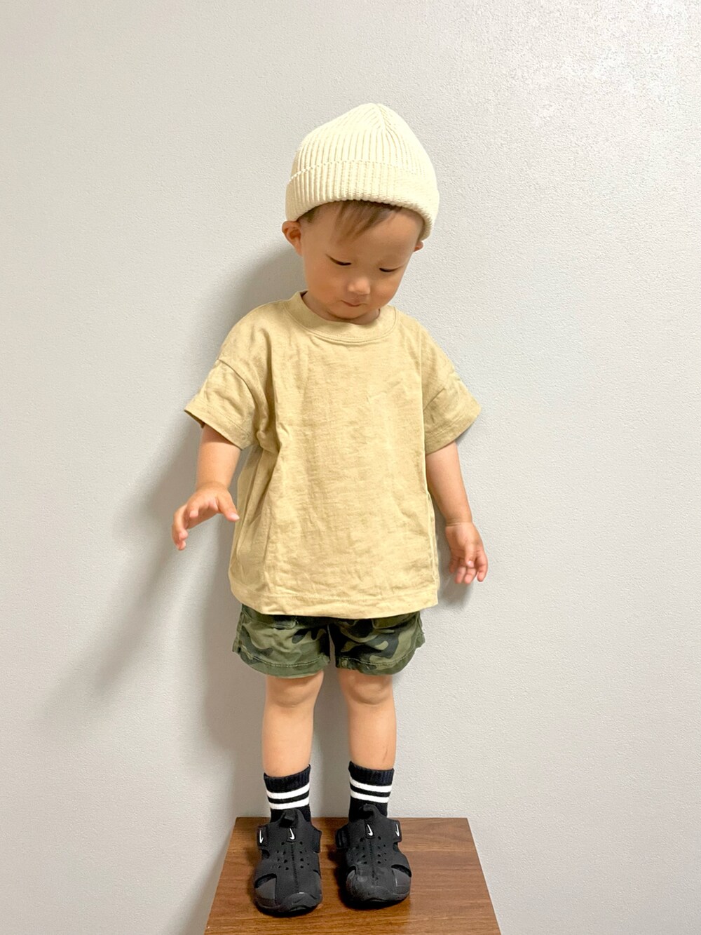 グリーン系のカーゴパンツ、ブラック系のサンダル、ホワイト系のニットキャップ/ビーニーを着用したキッズの春コーディネートの2枚目の写真