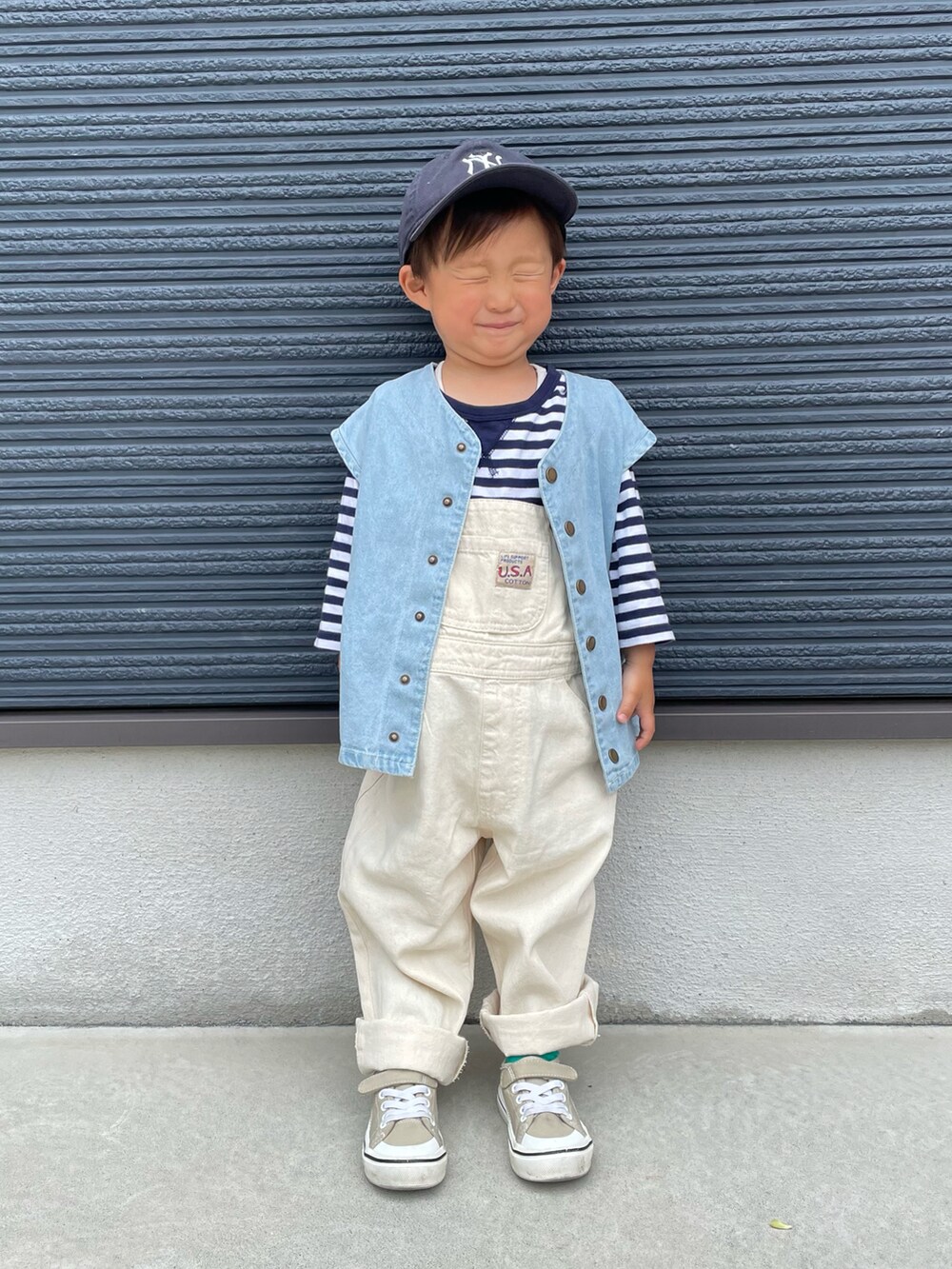 ホワイト系のサロペット/オーバーオール、ブルー系のベスト、ブルー系のTシャツ/カットソーを着用したキッズの春コーディネートの2枚目の写真