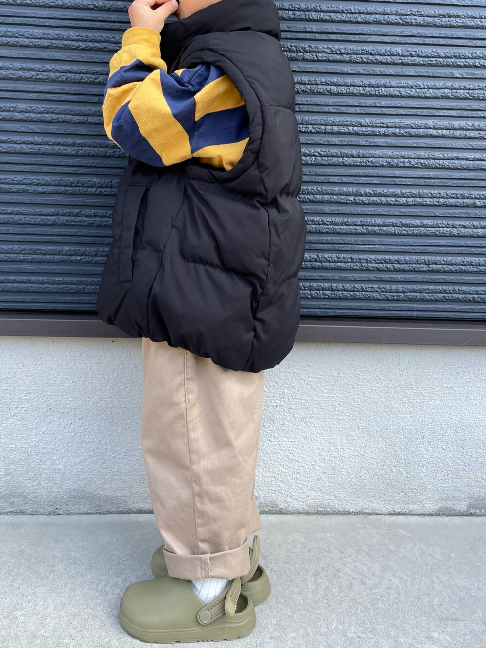 ブラック系のブルゾン、イエロー系のTシャツ/カットソー、ベージュ系のチノパンツを着用したキッズの秋コーディネートの4枚目の写真