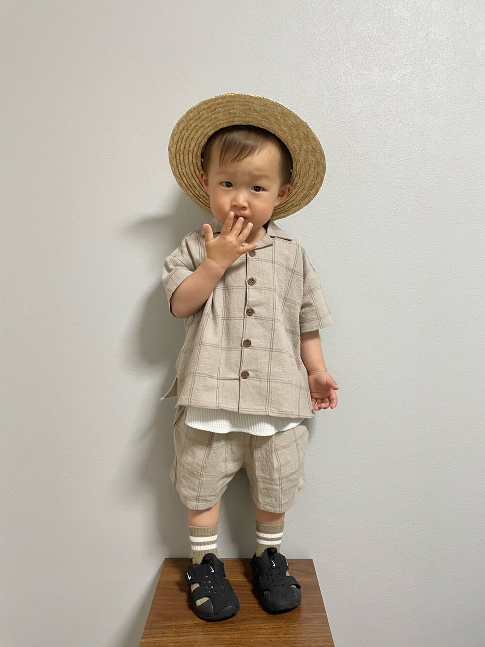 ブラック系のサンダル、ベージュ系のセットアップ、ホワイト系のタンクトップを着用したキッズの春コーディネートの2枚目の写真