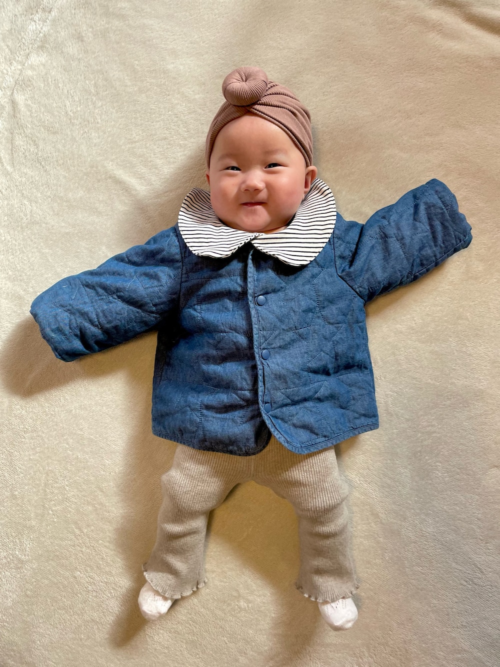 ブルー系のノーカラージャケット、ベージュ系のセットアップ、ブラック系のロンパースを着用したキッズの冬コーディネートの2枚目の写真