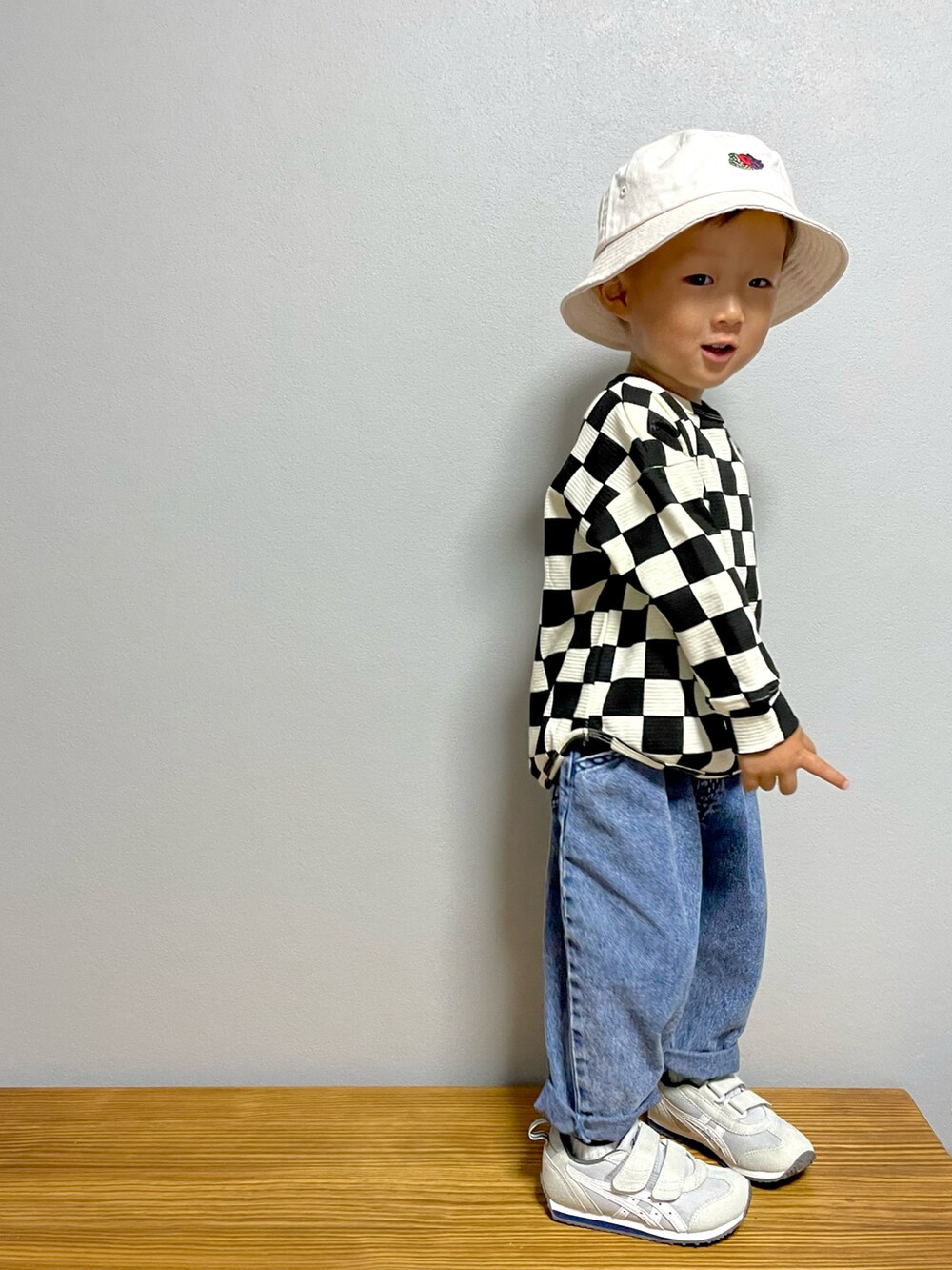 ブラック系のTシャツ/カットソー、ブルー系のデニムパンツ、グレー系のスニーカーを着用したキッズの秋コーディネートの5枚目の写真