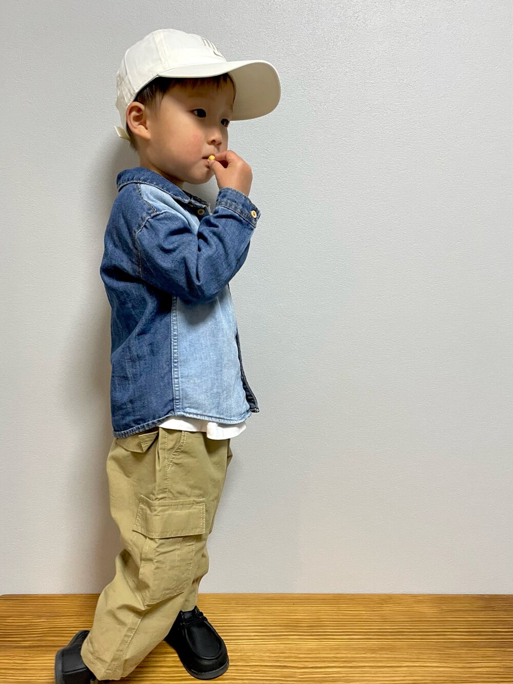 ホワイト系のTシャツ/カットソー、ベージュ系のカーゴパンツ、ブラック系のブーツを着用したキッズの春コーディネートの3枚目の写真