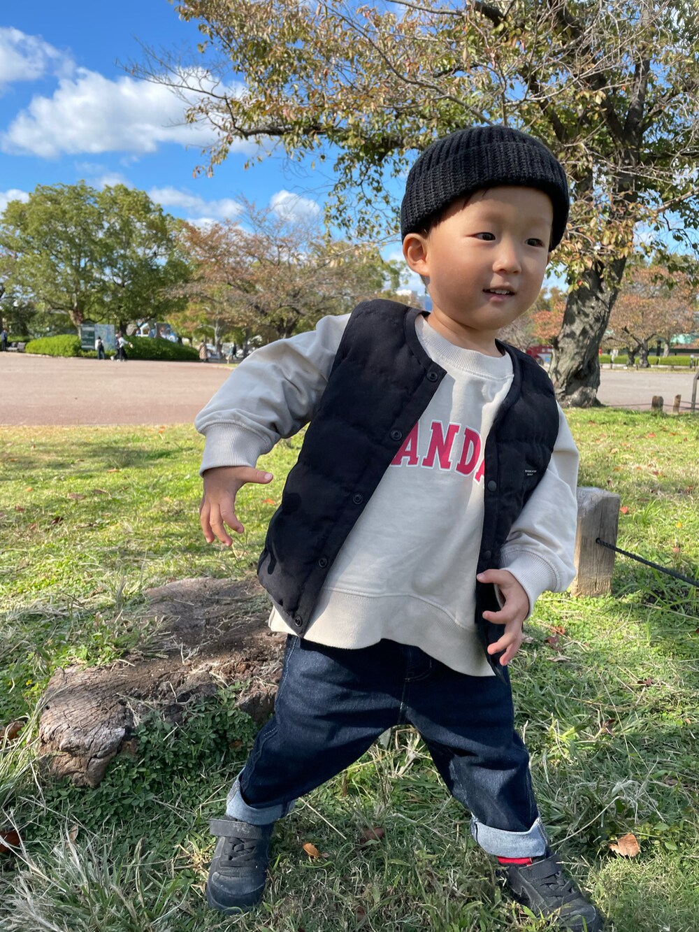 ベージュ系のスウェット、ブラック系のダウンベスト、ブルー系のデニムパンツを着用したキッズの秋コーディネートの3枚目の写真