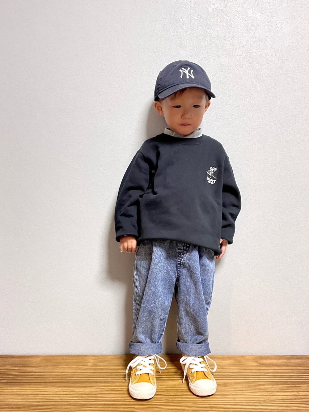 ブルー系のデニムパンツ、ブラック系のスウェット、ブラウン系のサンダルを着用したキッズの秋コーディネートの4枚目の写真