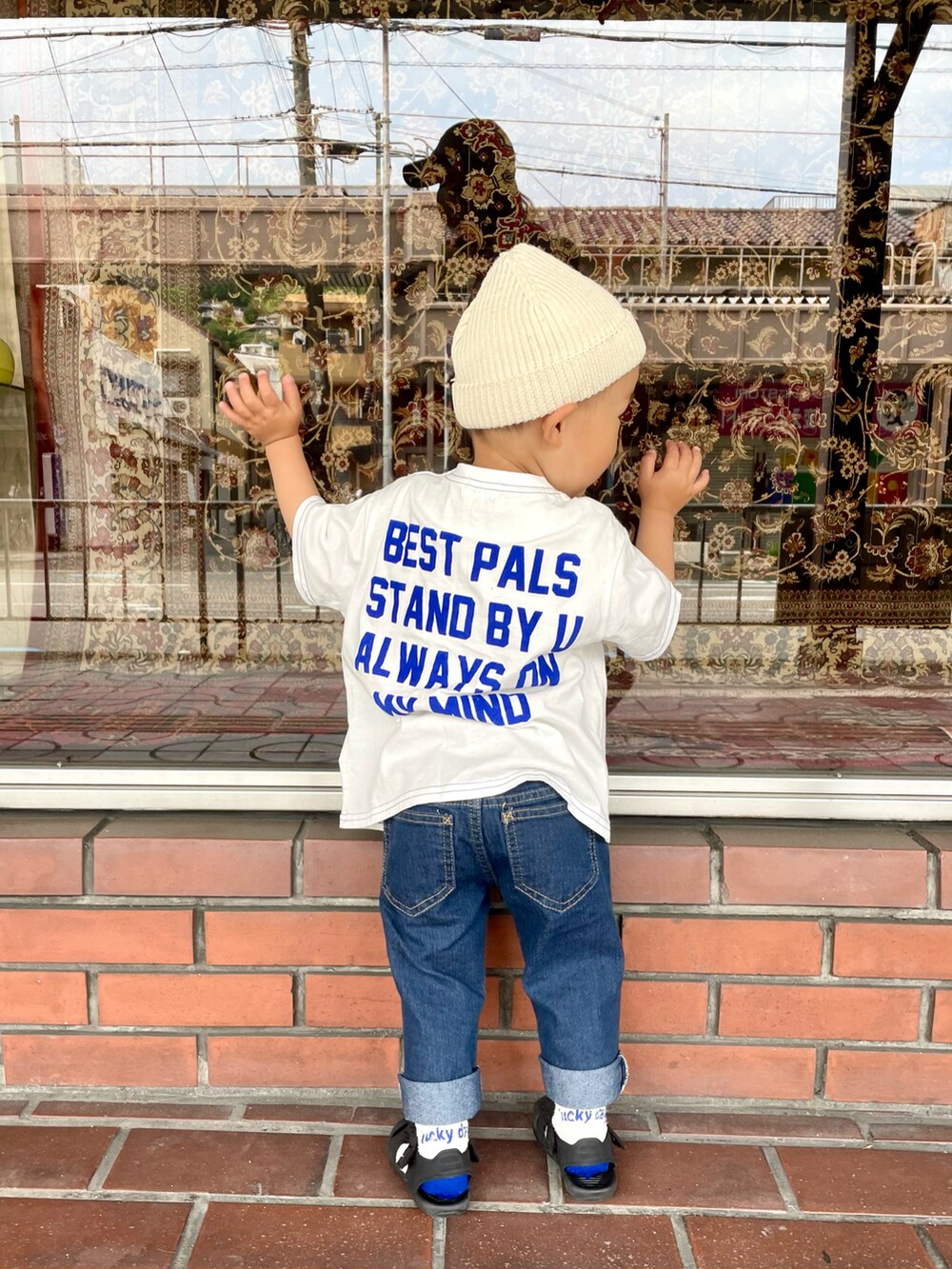 ブラック系のノーカラージャケット、ホワイト系のTシャツ/カットソー、ブルー系のデニムパンツを着用したキッズの春コーディネートの4枚目の写真