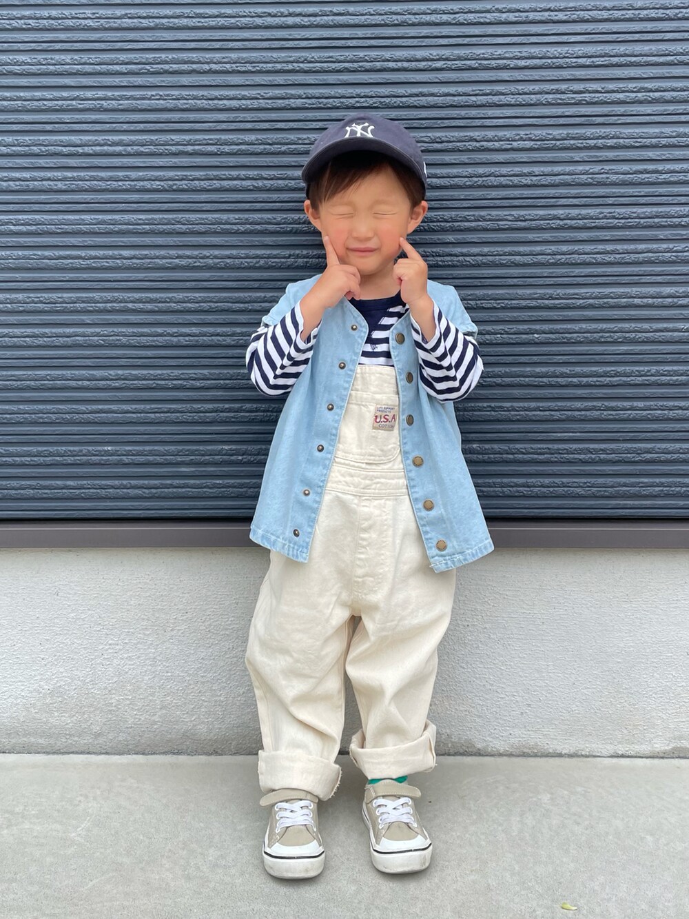 ホワイト系のサロペット/オーバーオール、ブルー系のベスト、ブルー系のTシャツ/カットソーを着用したキッズの春コーディネートの3枚目の写真