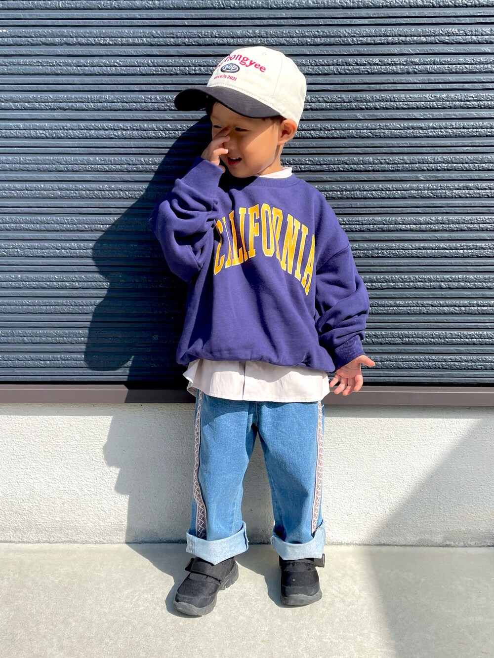 ブルー系のスウェット、ベージュ系のシャツ/ブラウス、ブルー系のデニムパンツを着用したキッズの秋コーディネートの4枚目の写真