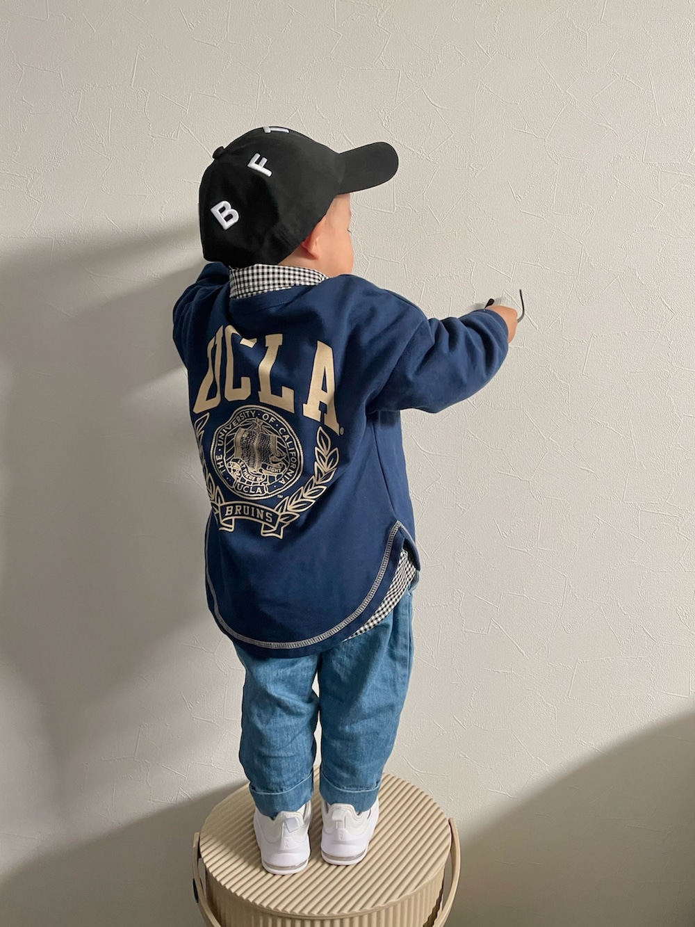 グリーン系のスウェット、ブラック系のシャツ/ブラウス、ブルー系のデニムパンツを着用したキッズの春コーディネートの3枚目の写真