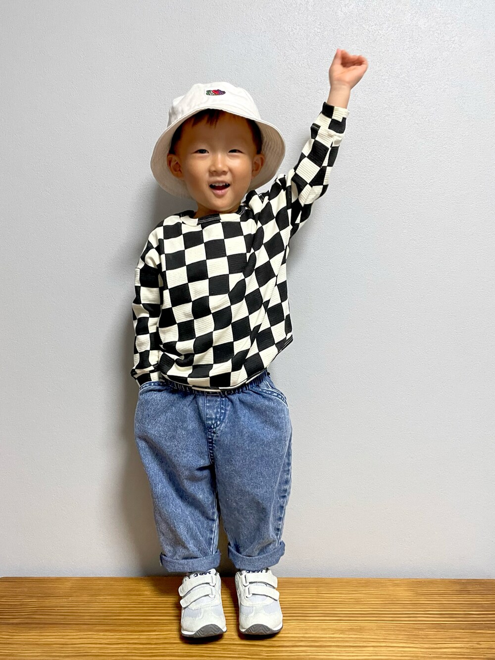 ブラック系のTシャツ/カットソー、ブルー系のデニムパンツ、グレー系のスニーカーを着用したキッズの秋コーディネートの2枚目の写真