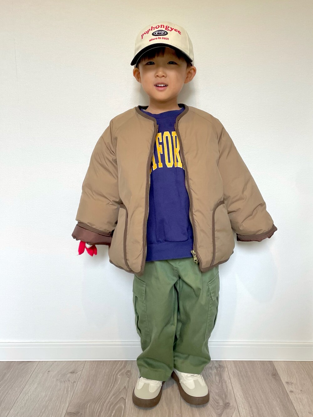 ブルー系のスウェット、ブラウン系のノーカラージャケット、グリーン系のカーゴパンツを着用したキッズの冬コーディネートの2枚目の写真