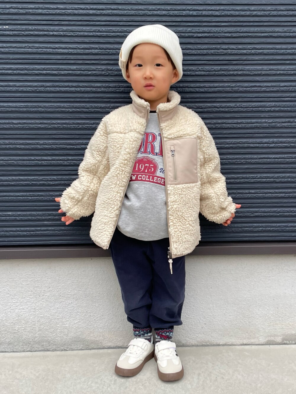 グレー系のスウェット、ベージュ系のその他アウター、ブルー系のスウェットパンツを着用したキッズの冬コーディネートの2枚目の写真