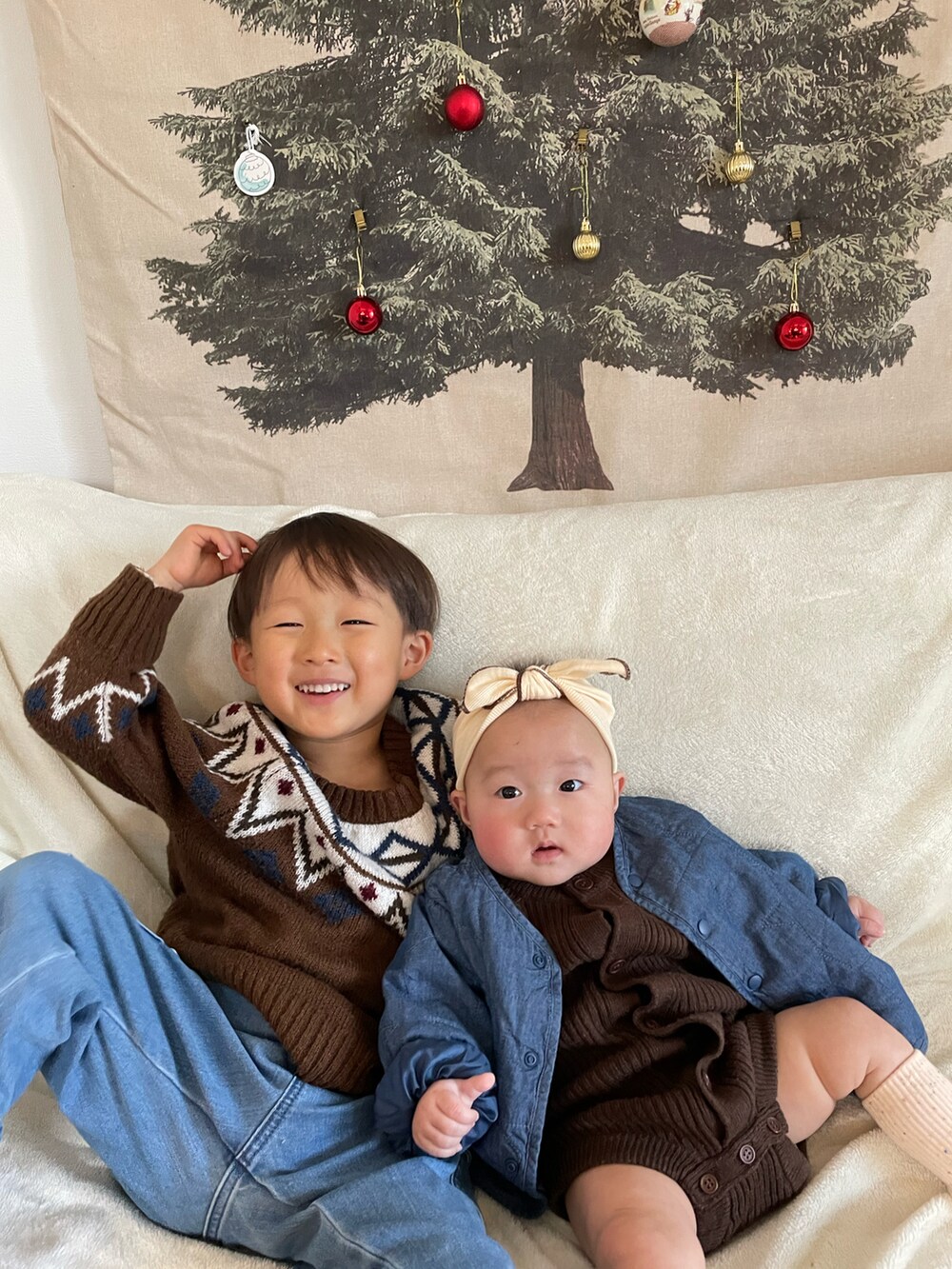 ブラウン系のニット/セーター、グリーン系のノーカラージャケット、ブルー系のカーゴパンツを着用したキッズの冬コーディネートの5枚目の写真