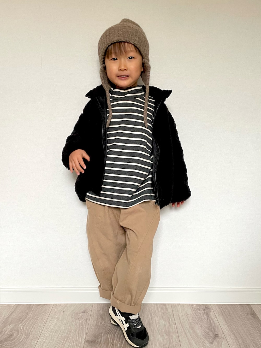 ブラック系のTシャツ/カットソー、ベージュ系のパンツ、ブラック系のスニーカーを着用したキッズの冬コーディネートの3枚目の写真