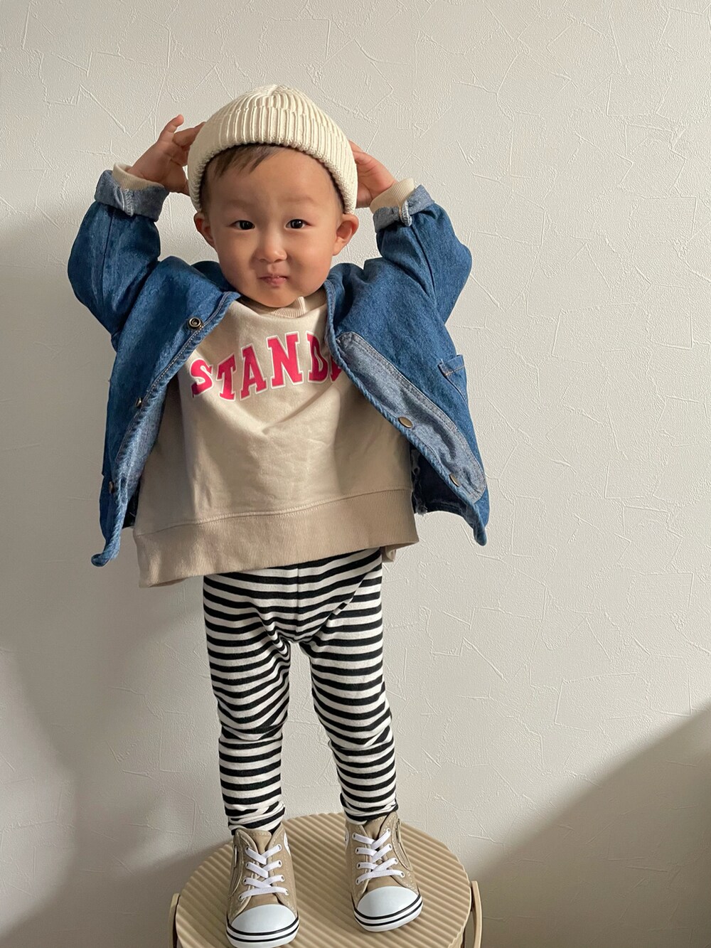 ベージュ系のスウェット、ブルー系のデニムジャケット、ベージュ系のスニーカーを着用したキッズの春コーディネートの5枚目の写真