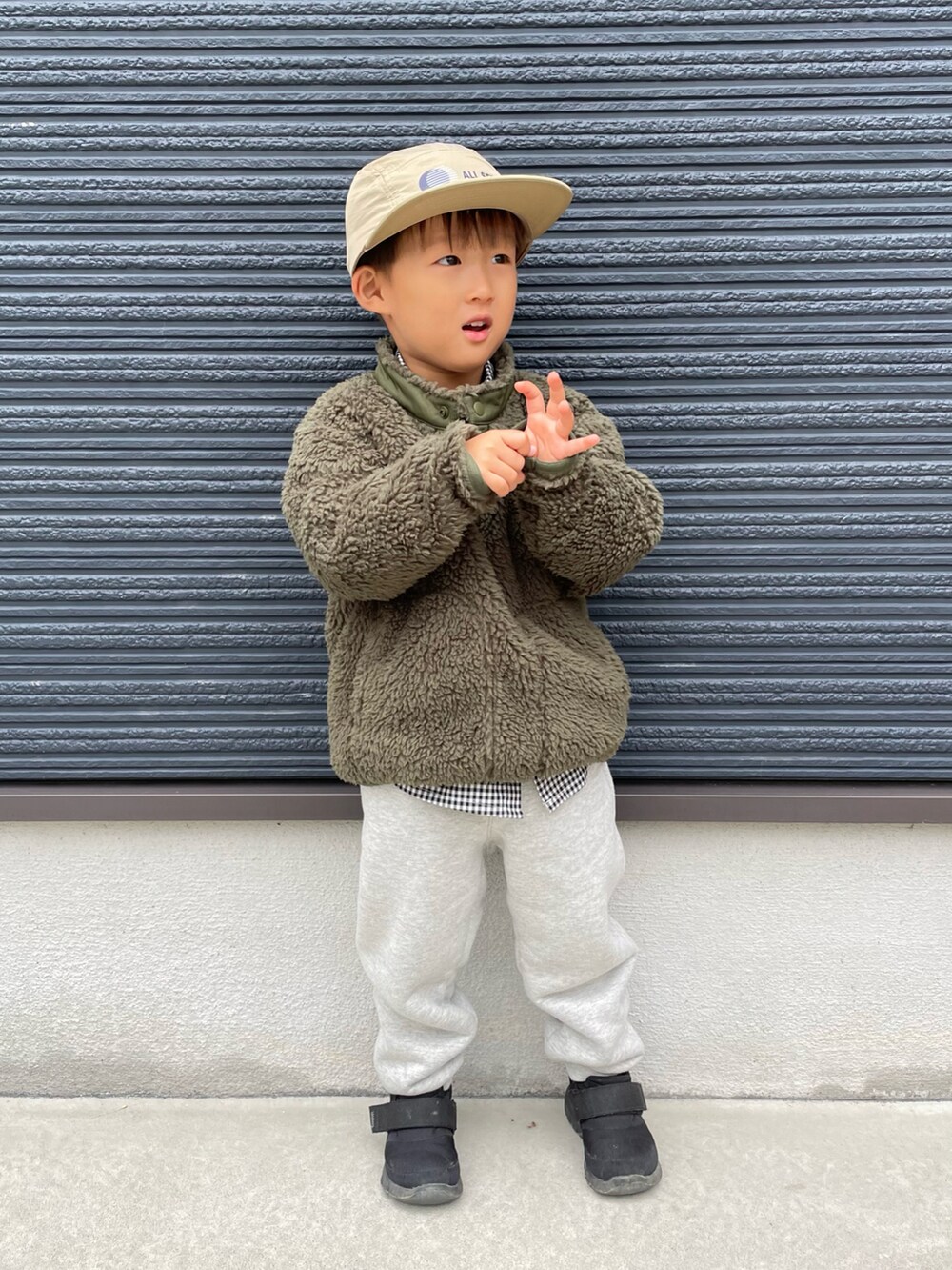 グリーン系のブルゾン、ブラック系のシャツ/ブラウス、ブラック系のスニーカーを着用したキッズの秋コーディネートの5枚目の写真