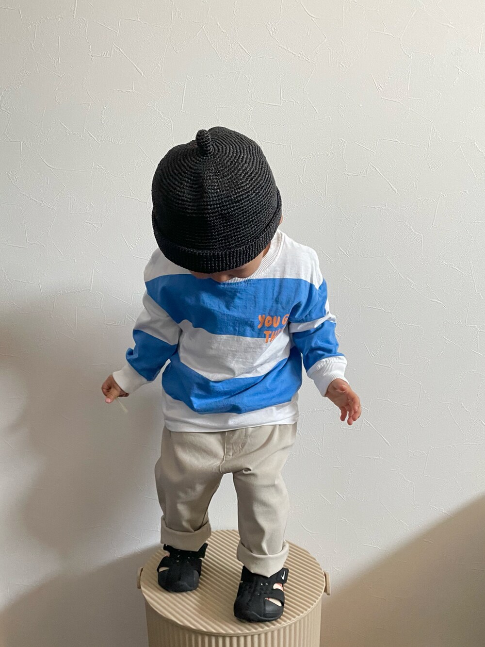 ホワイト系のTシャツ/カットソー、ブラック系のサンダル、ブラック系のキャップを着用したキッズの春コーディネートの3枚目の写真