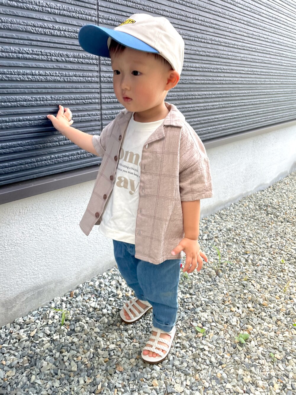 ベージュ系のセットアップ、ベージュ系のTシャツ/カットソー、ブルー系のデニムパンツを着用したキッズの夏コーディネートの4枚目の写真