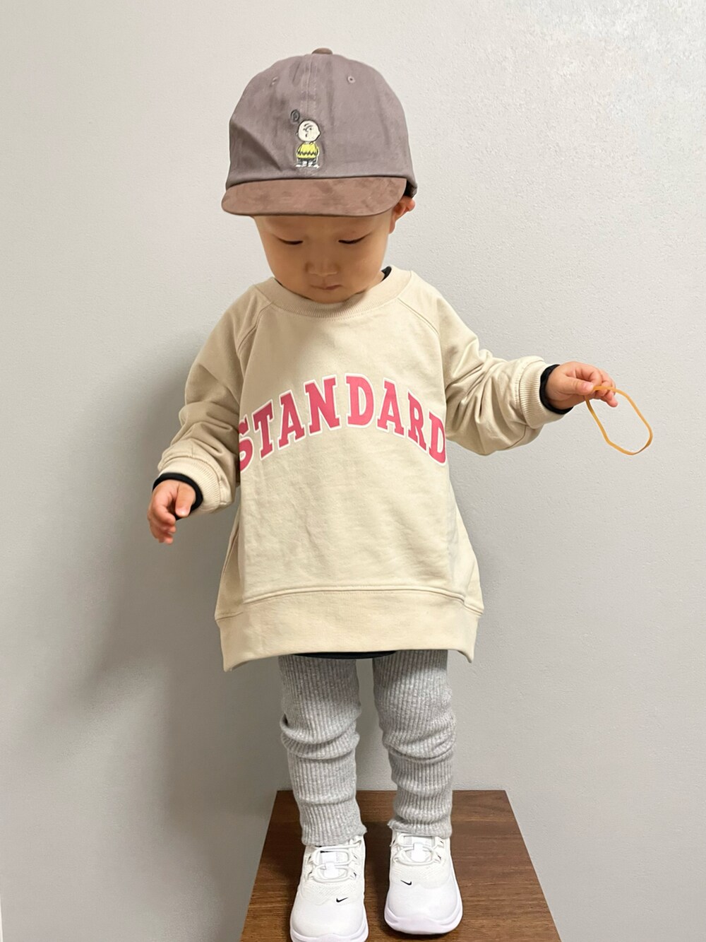 ベージュ系のスウェット、ブラウン系のエコバッグ/サブバッグ、ブラック系のTシャツ/カットソーを着用したキッズの冬コーディネートの2枚目の写真