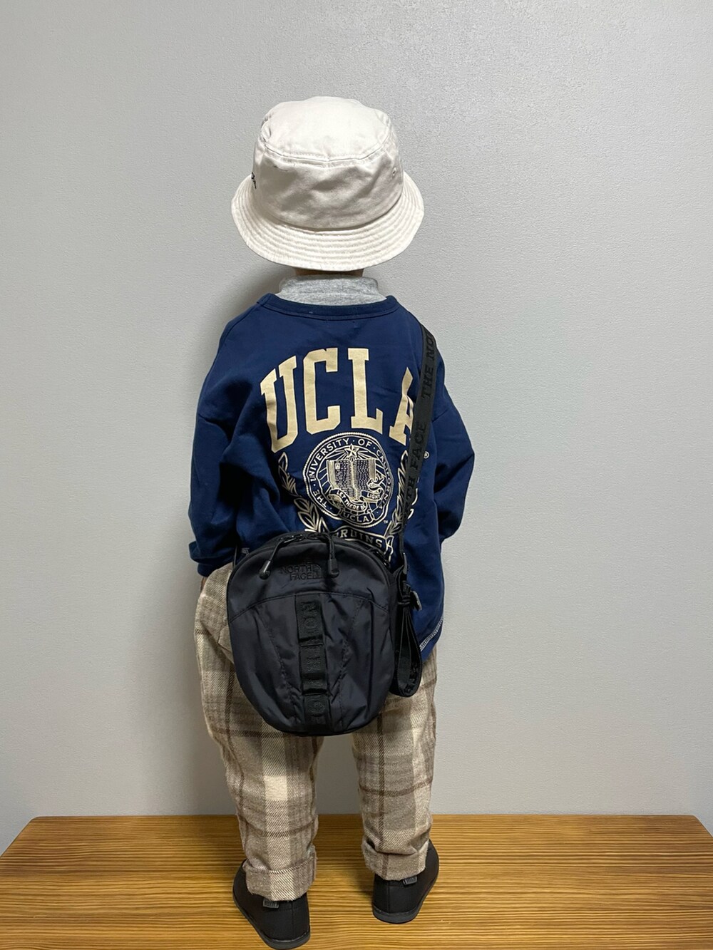 グリーン系のスウェット、ブラック系のブーツ、ブラック系のショルダーバッグを着用したキッズの春コーディネートの5枚目の写真