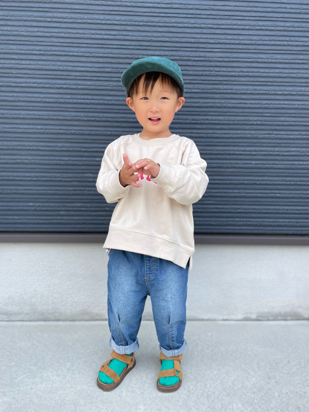 ベージュ系のスウェット、ブルー系のデニムパンツ、ブラウン系のサンダルを着用したキッズの春コーディネートの3枚目の写真