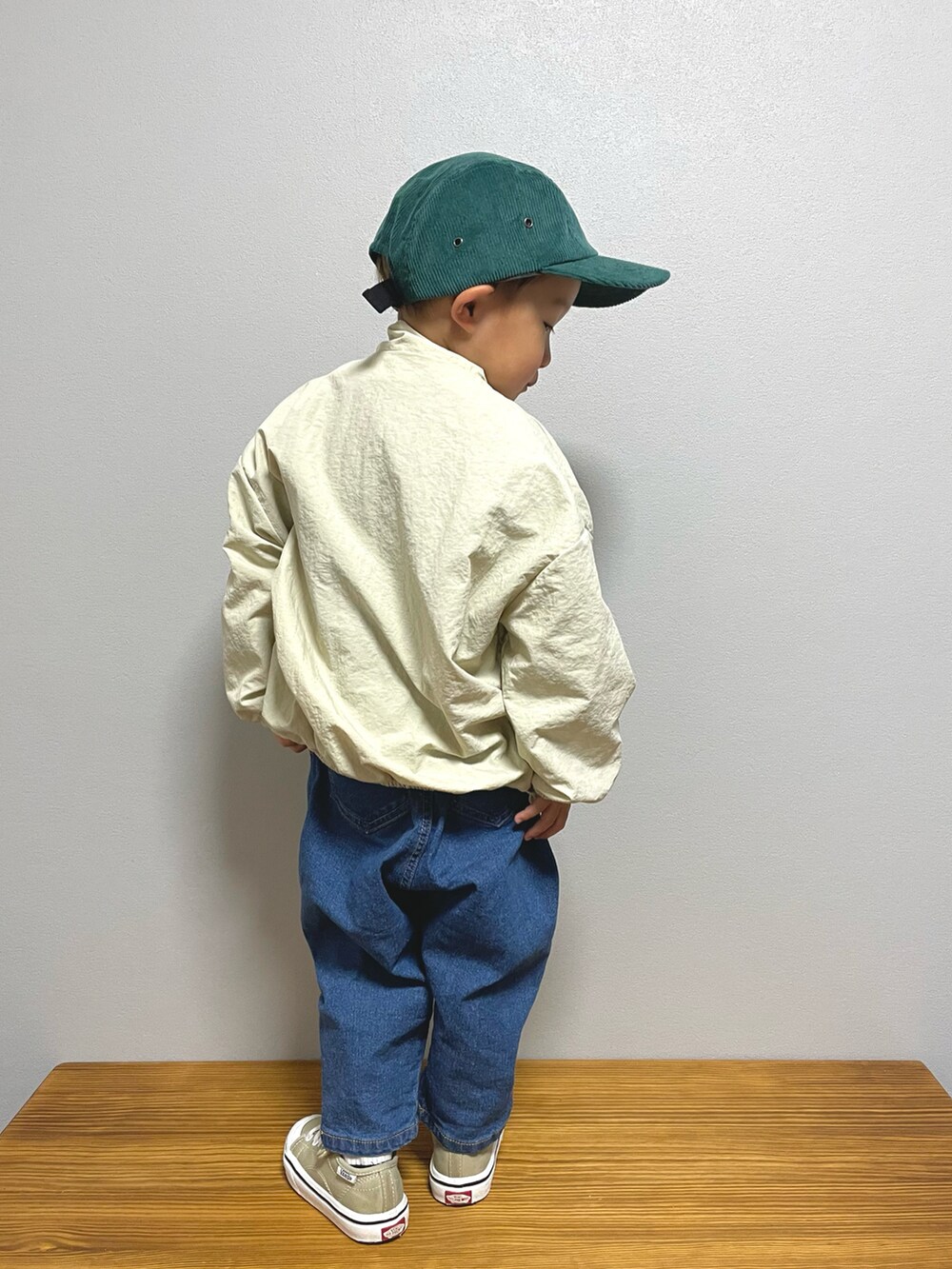 ベージュ系のナイロンジャケット、ホワイト系のTシャツ/カットソー、ブルー系のデニムパンツを着用したキッズの春コーディネートの2枚目の写真