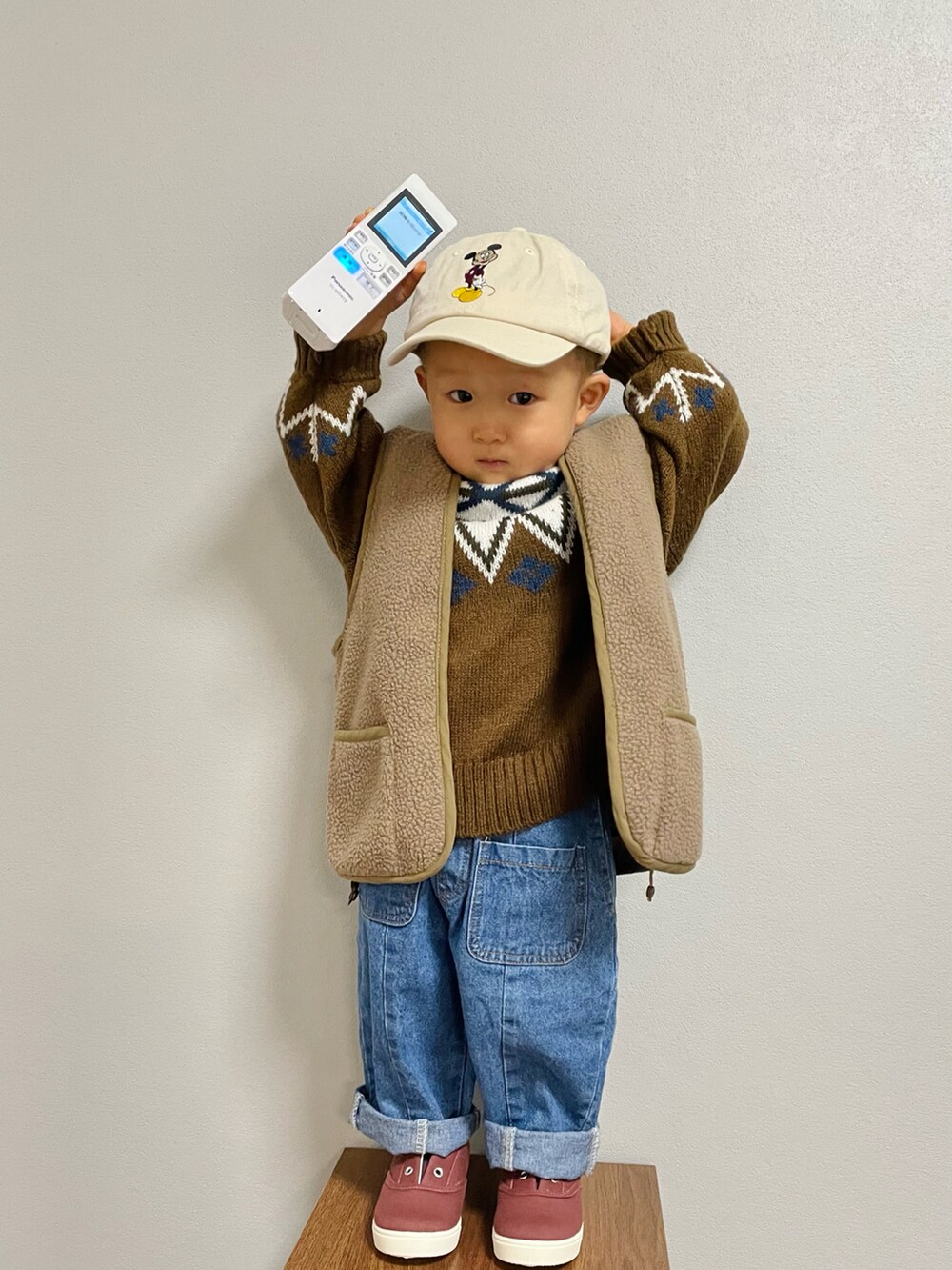 グリーン系のその他アウター、ブラウン系のニット/セーター、ブルー系のデニムパンツを着用したキッズの冬コーディネートの4枚目の写真