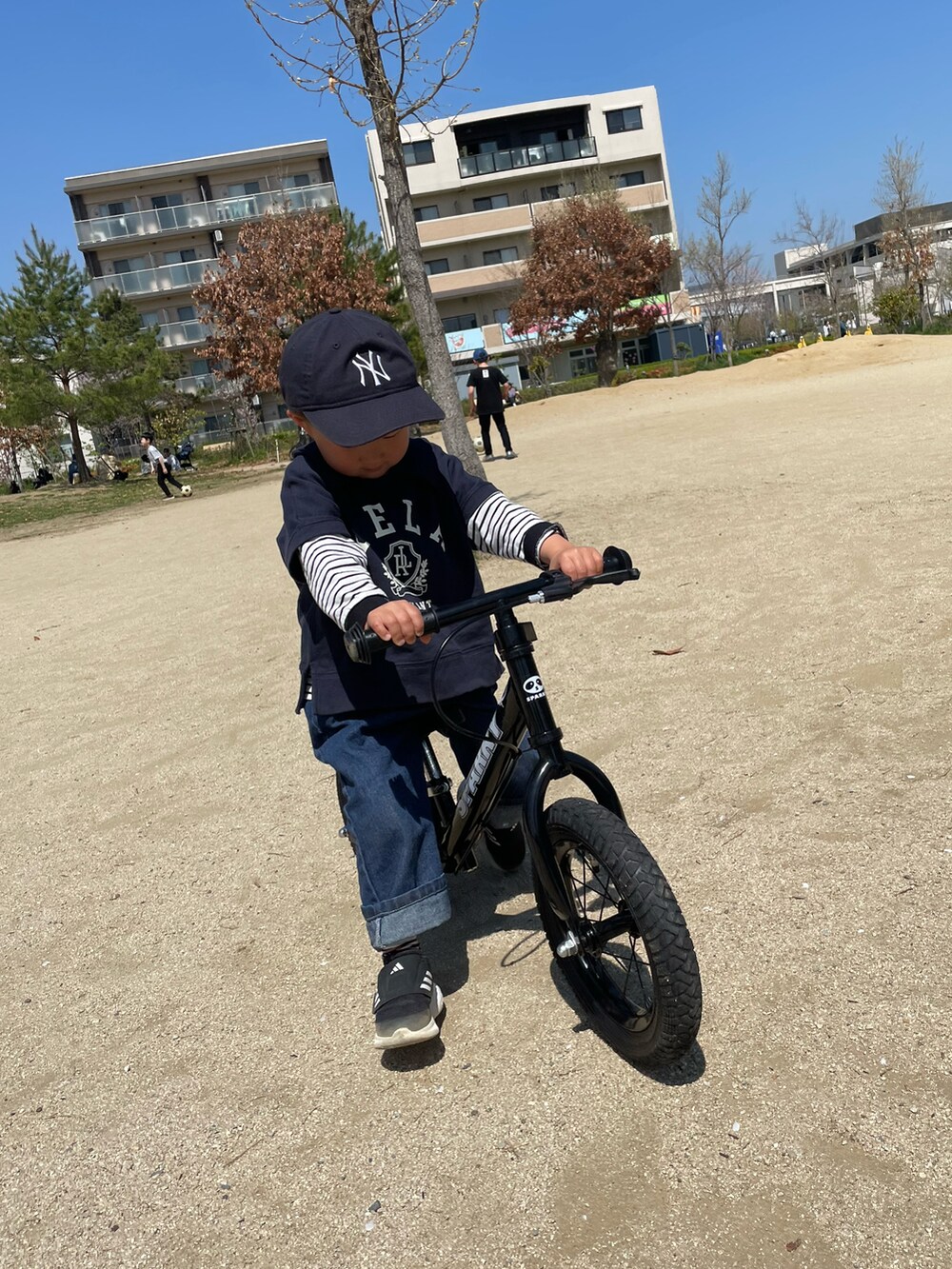 ブルー系のスウェット、ブラック系のTシャツ/カットソー、ブルー系のデニムパンツを着用したキッズの春コーディネートの5枚目の写真