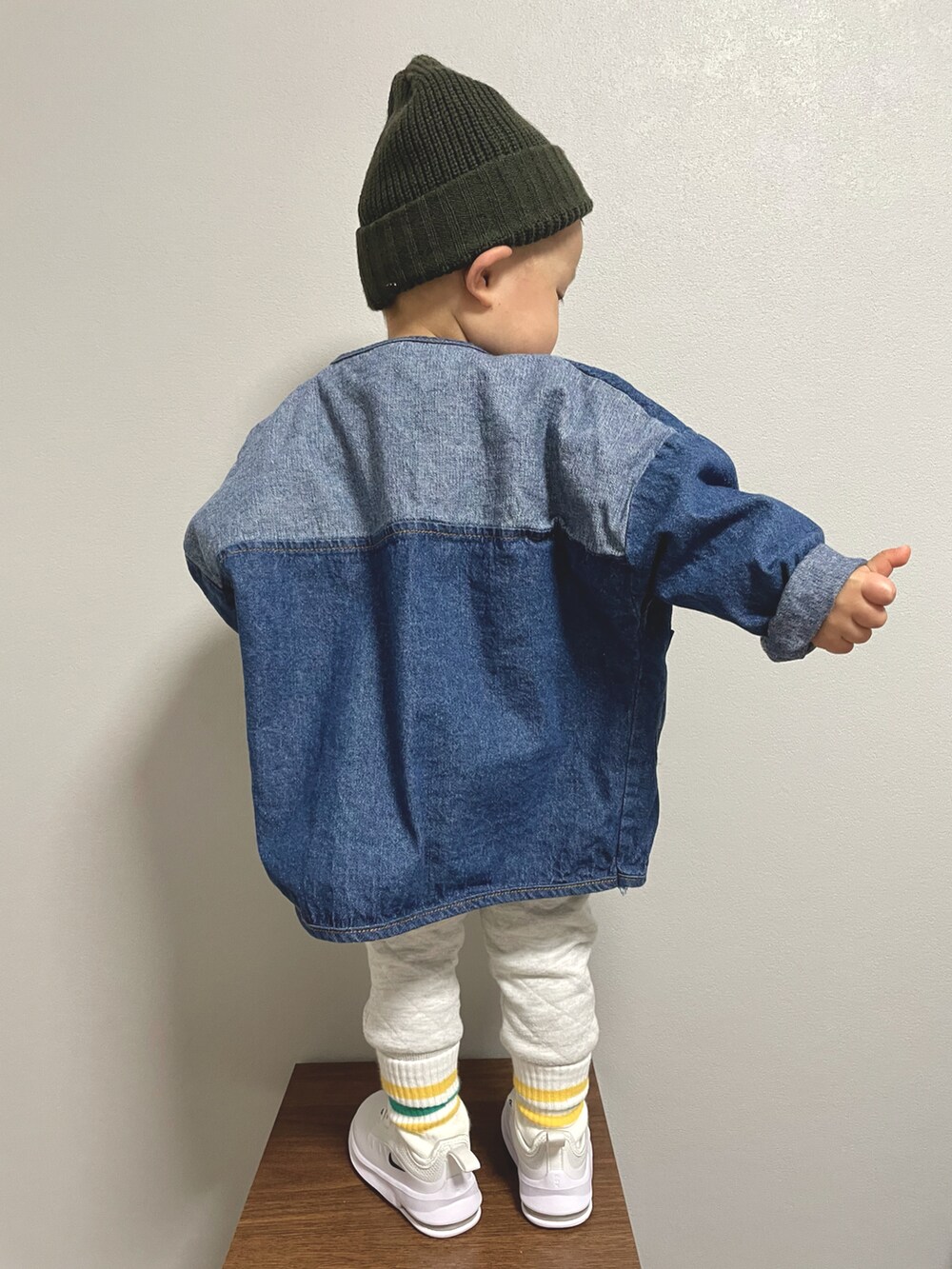 イエロー系のスウェット、ブルー系のデニムジャケット、ホワイト系のその他パンツを着用したキッズの冬コーディネートの5枚目の写真