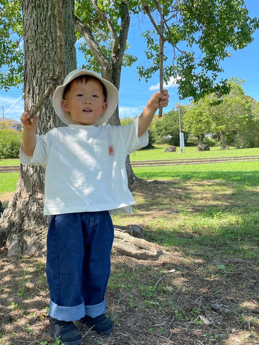 ホワイト系のTシャツ/カットソー、ブルー系のデニムパンツ、ブラック系のスニーカーを着用したキッズの秋コーディネートの4枚目の写真