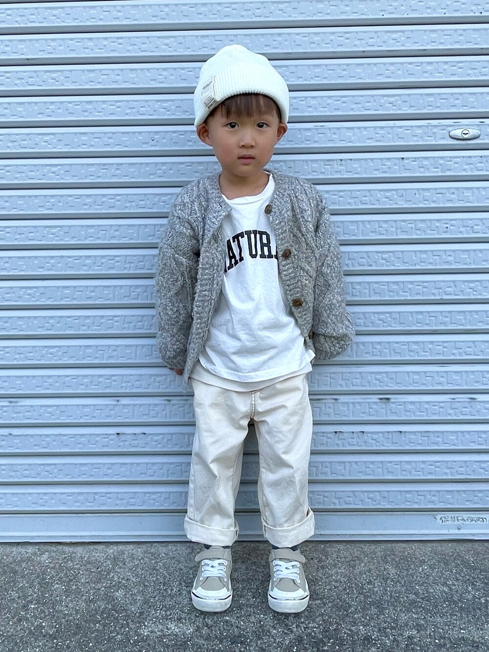 ホワイト系のTシャツ/カットソー、グレー系のカーディガン/ボレロ、ホワイト系のデニムパンツを着用したキッズの秋コーディネートの4枚目の写真