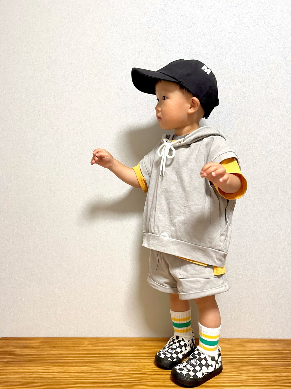 グレー系のスウェット、ブラック系のスリッポン、オレンジ系のTシャツ/カットソーを着用したキッズの春コーディネートの4枚目の写真