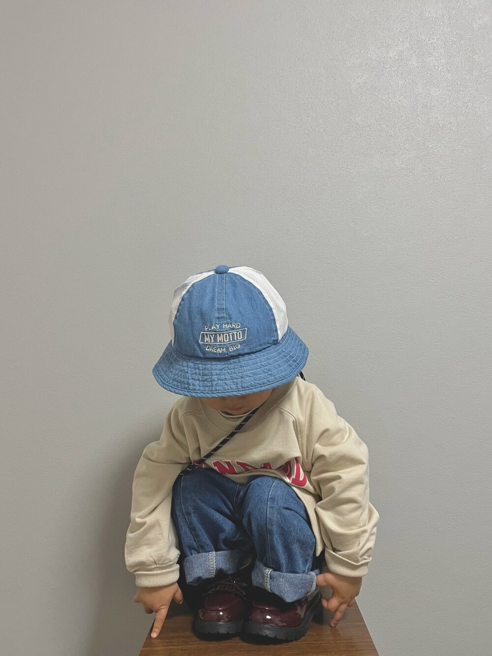 ベージュ系のスウェット、ブラック系のショルダーバッグ、ホワイト系のTシャツ/カットソーを着用したキッズの冬コーディネートの2枚目の写真