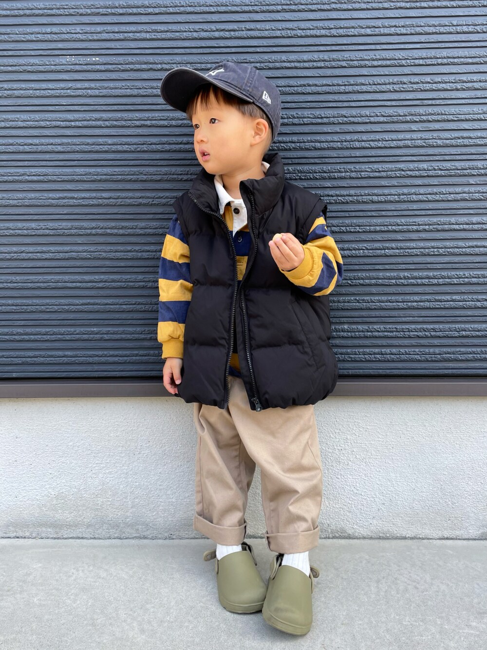 ブラック系のブルゾン、イエロー系のTシャツ/カットソー、ベージュ系のチノパンツを着用したキッズの秋コーディネートの3枚目の写真