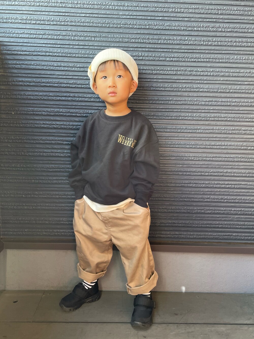 ブラック系のスニーカー、ブラック系のスウェット、ベージュ系のチノパンツを着用したキッズの秋コーディネートの2枚目の写真