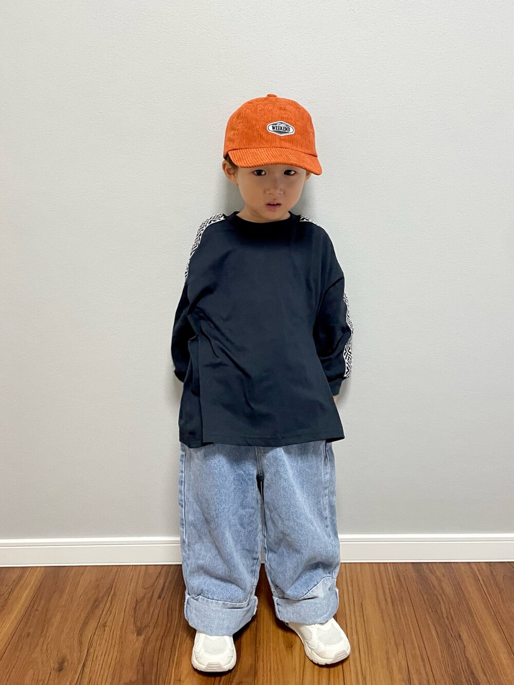 ブラック系のTシャツ/カットソー、ブルー系のデニムパンツ、ホワイト系のスニーカーを着用したキッズの秋コーディネートの2枚目の写真